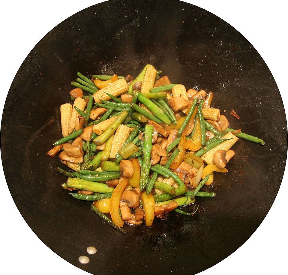 Setas salteadas con maíz tierno en un plato negro